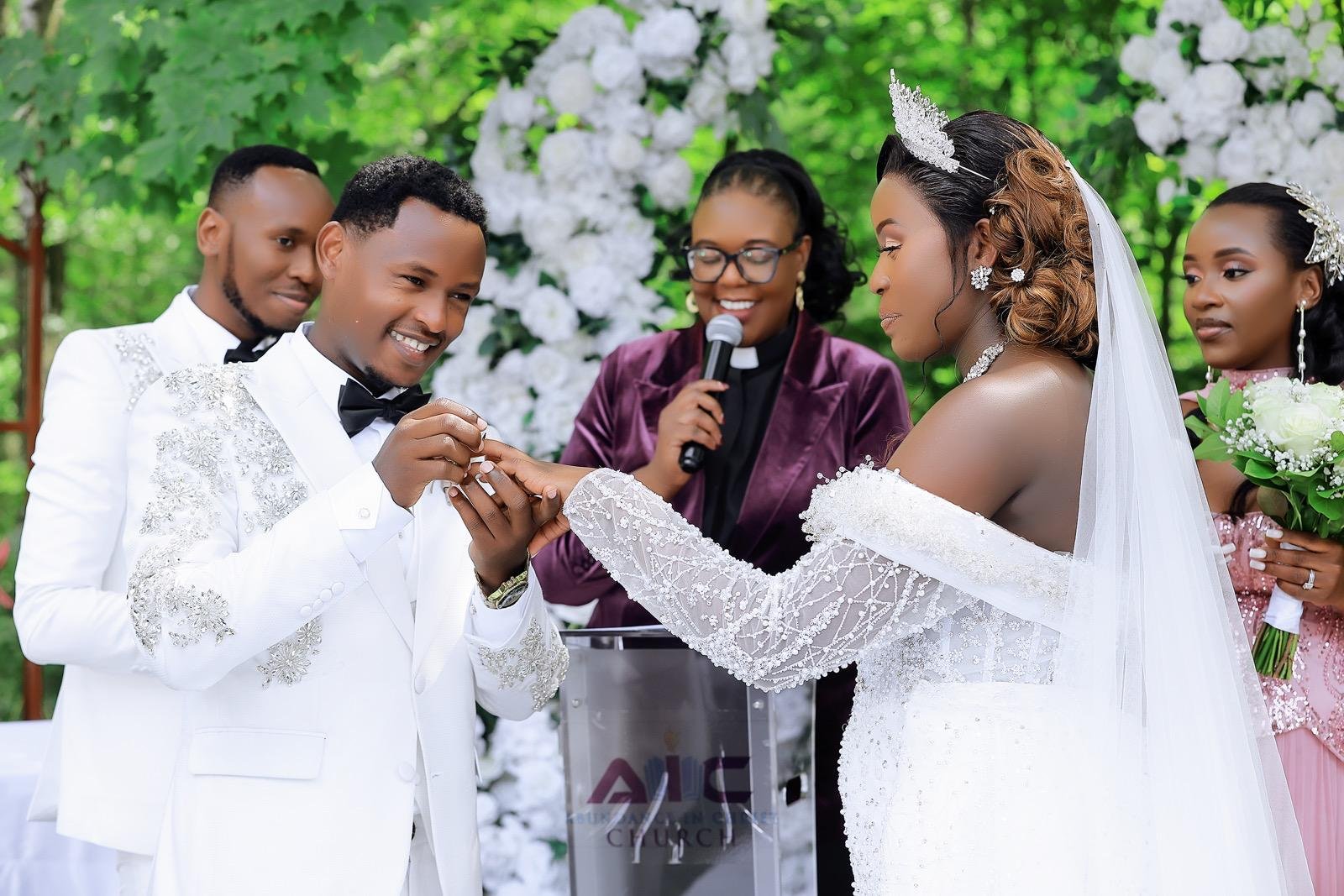 Bride and groom exchanging rings with their officiant at an outdoor wedding